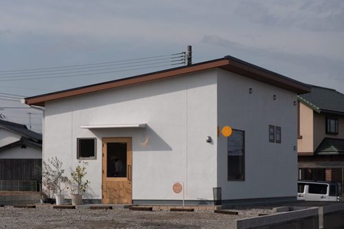白い壁とまるい看板が目印のお店の外観