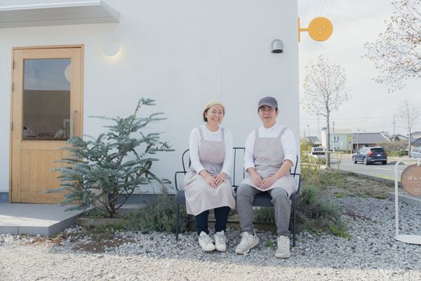 お店の前のベンチに並んで座る店主ふたり